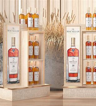 Bottle of Macallan 12 whisky on a wooden table next to a laptop showing an online store checkout. Where to Buy Macallan Online